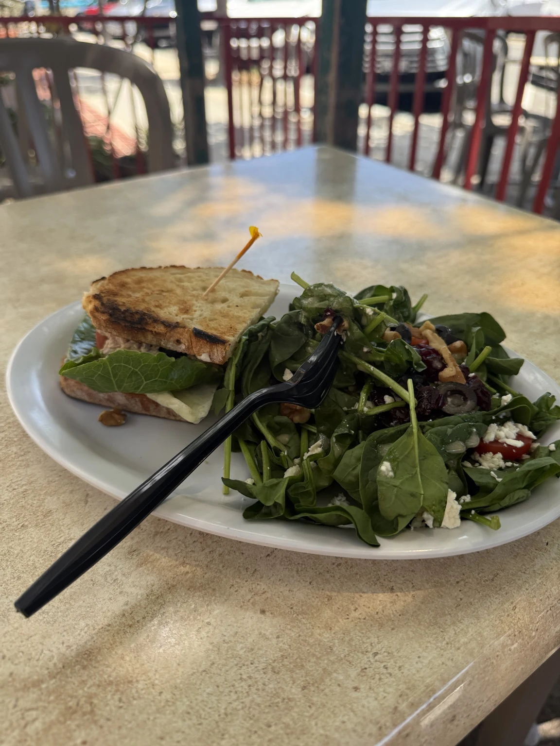 A sandwich and salad photographed in cooler café shade